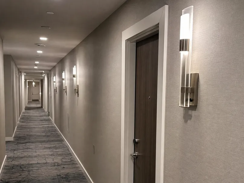 Decorative hotel corridor wall sconces in coordinated finish