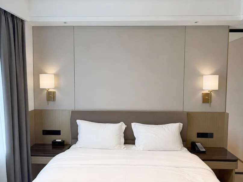 Matching hotel guestroom bedside wall sconces with consistent finish