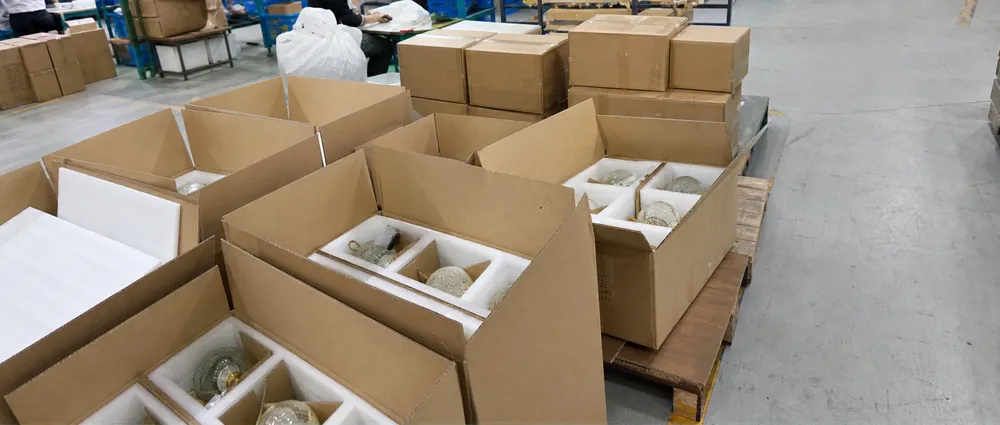 Foam-lined cartons with individually braced glass pendant fixtures prepared for ocean freight shipping