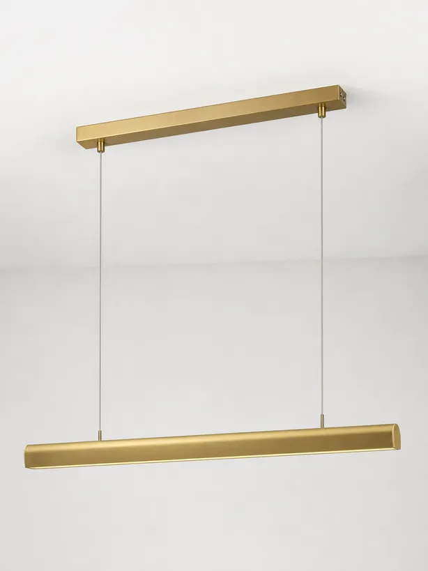 Linear suspension kitchen island fixture in brushed brass with CNC-machined canopy detail