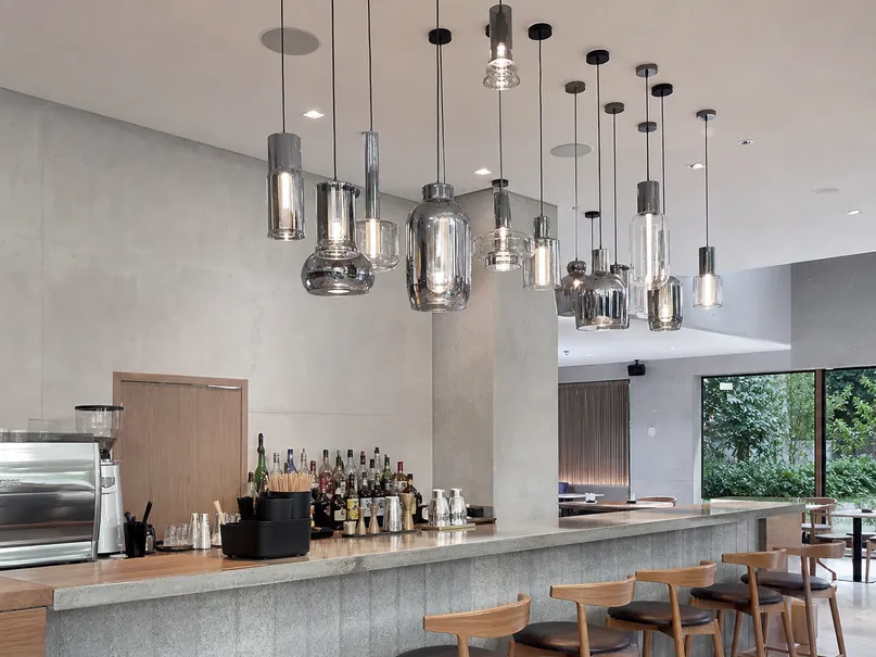 Cluster pendant lighting installation over a restaurant bar counter