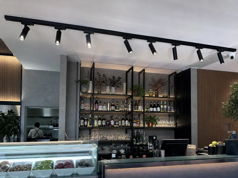 Track lighting system with adjustable spotlights over a restaurant bar display