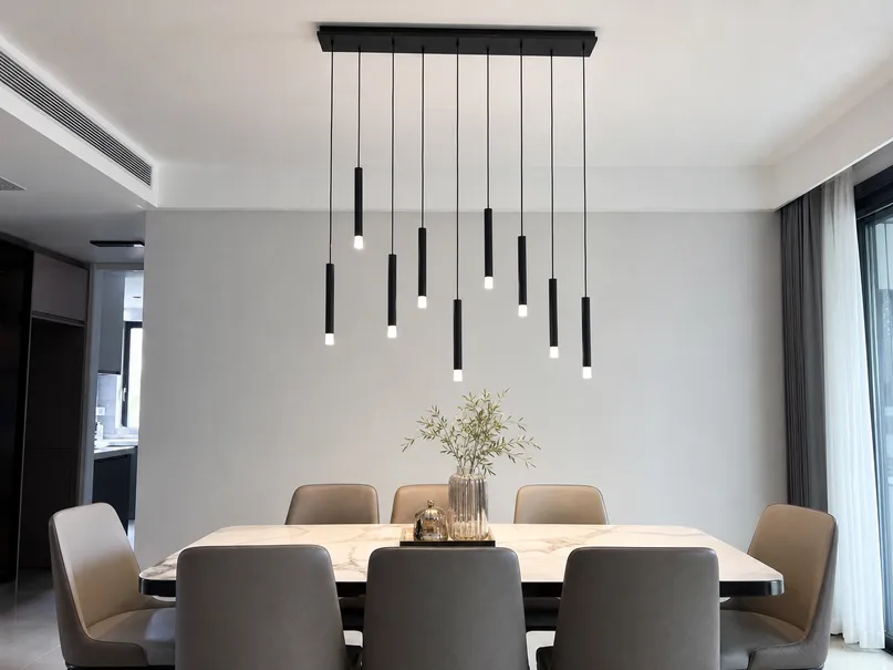 Pendant cluster with shared canopy over villa dining table, showing individual height adjustments