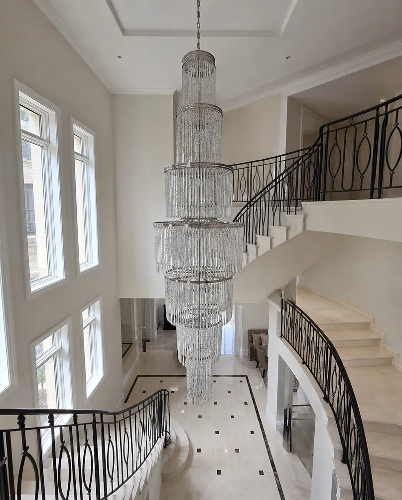 Multi-tier grand entry chandelier installed in a villa staircase with extended drop length