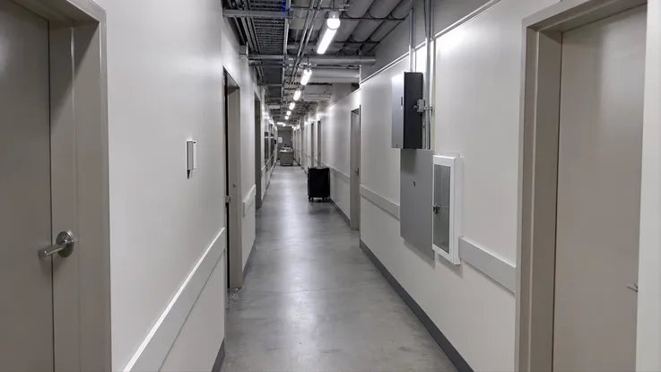 Industrial ceiling lighting installed in a hotel service corridor