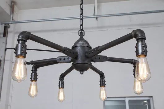 Industrial style chandelier pendant with exposed bulbs and iron pipe frame construction