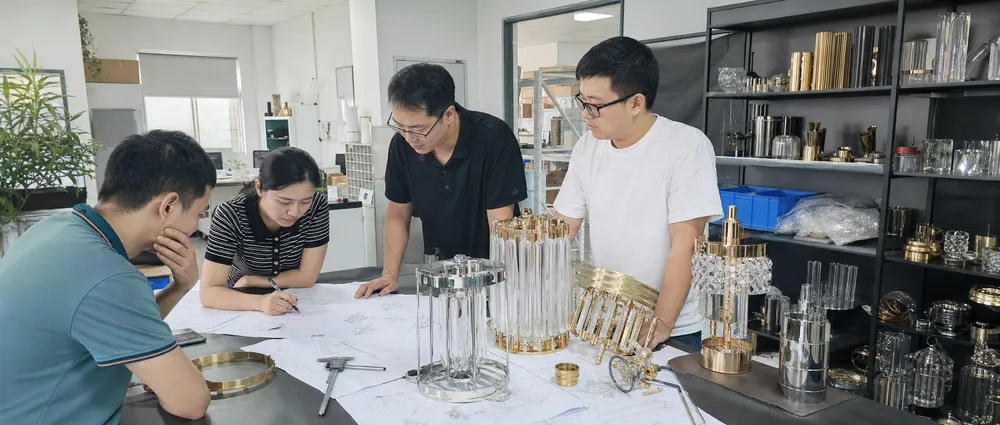 Engineering team reviewing chandelier pendant lighting prototype drawings and production samples