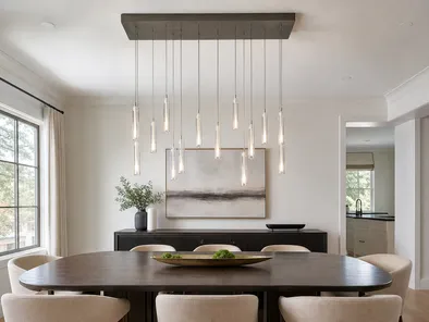 Linear chandelier suspended over a dining table with multiple pendant drops