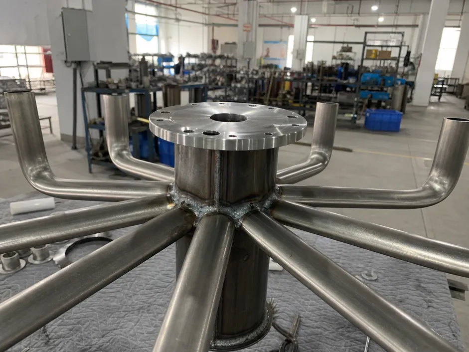 Multi-arm dining chandelier frame showing welded arm-to-body joints and CNC-machined canopy mount
