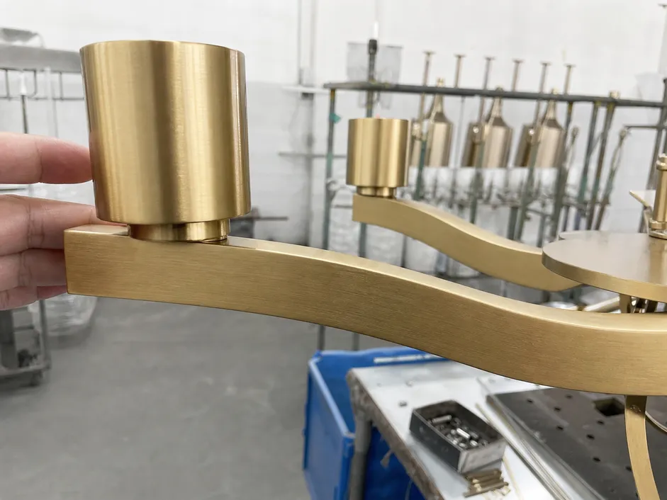 PVD brushed gold finish on dining room chandelier arm showing consistent color and surface hardness