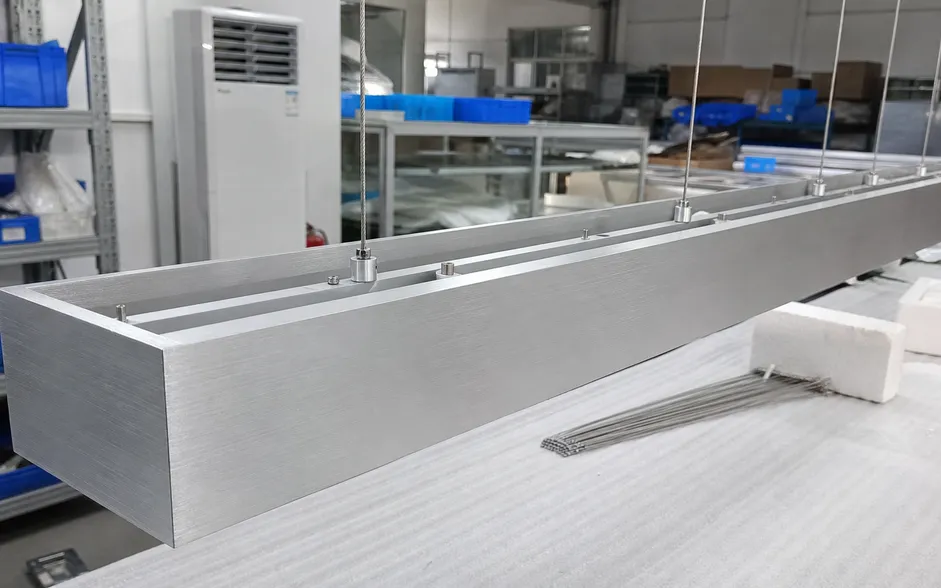 Close-up of linear chandelier frame showing precision aluminum extrusion and even suspension points