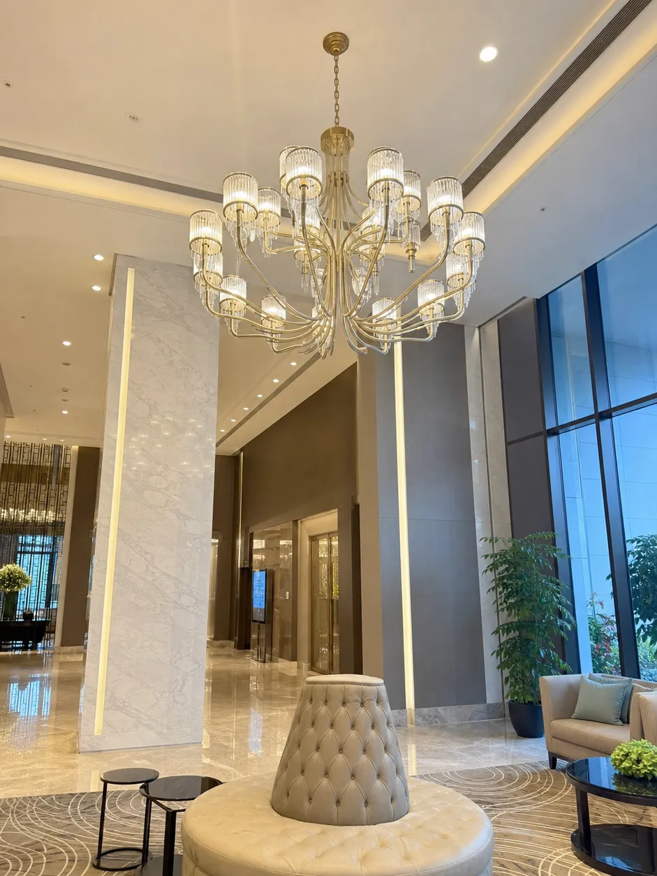 Luxury chandelier lighting with multi-arm gold finish design in hotel lobby setting