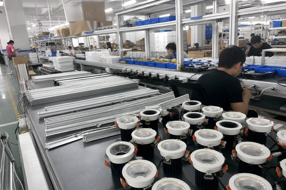 Architectural lighting fixtures in production — recessed downlights and linear profiles ready for project installation