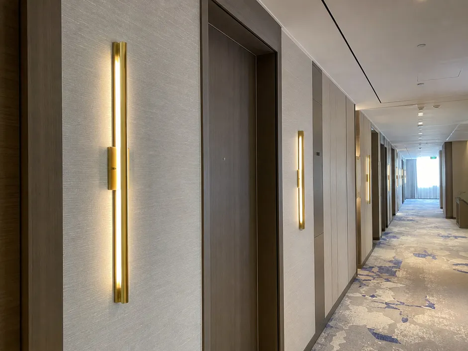 Linear wall sconce in brushed brass finish for hotel corridor application
