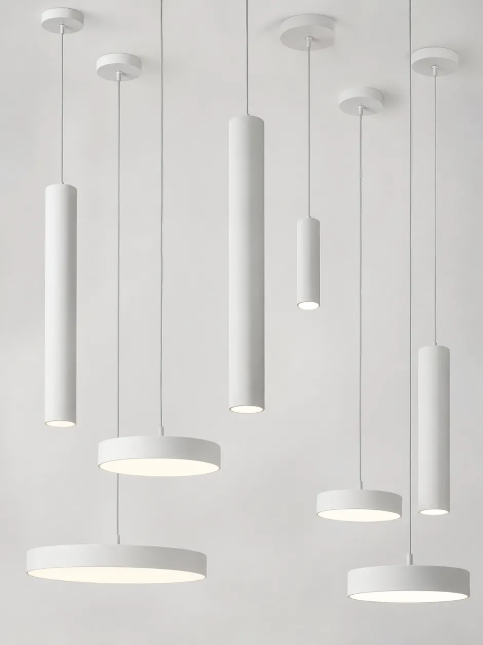 Minimalist pendant lighting collection featuring clean cylinder and disc profiles in matte white finish
