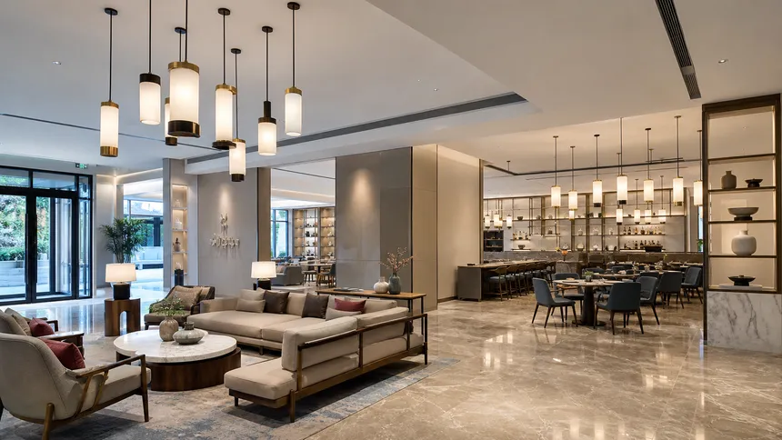 Custom pendant lighting installed across a hotel lobby and restaurant space