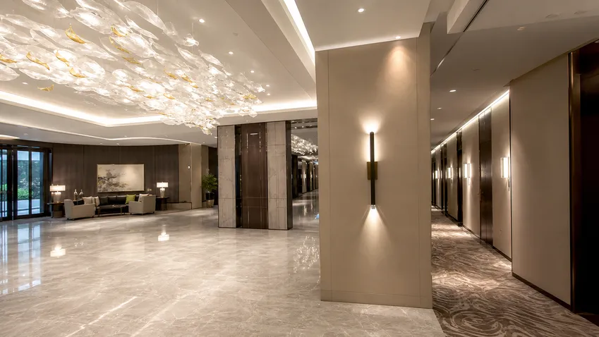 Custom decorative lighting installed across hotel lobby and guest room corridors