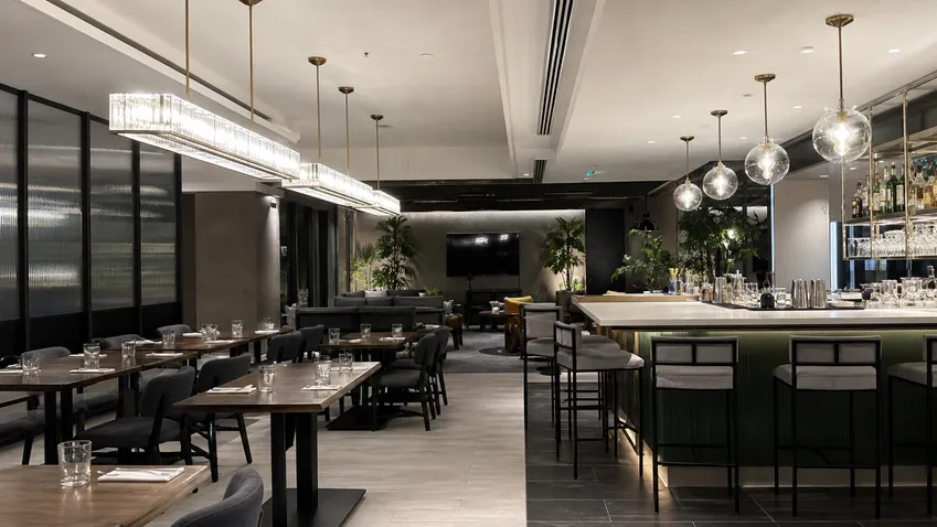 Linear chandeliers and cluster pendants installed in restaurant dining and bar areas