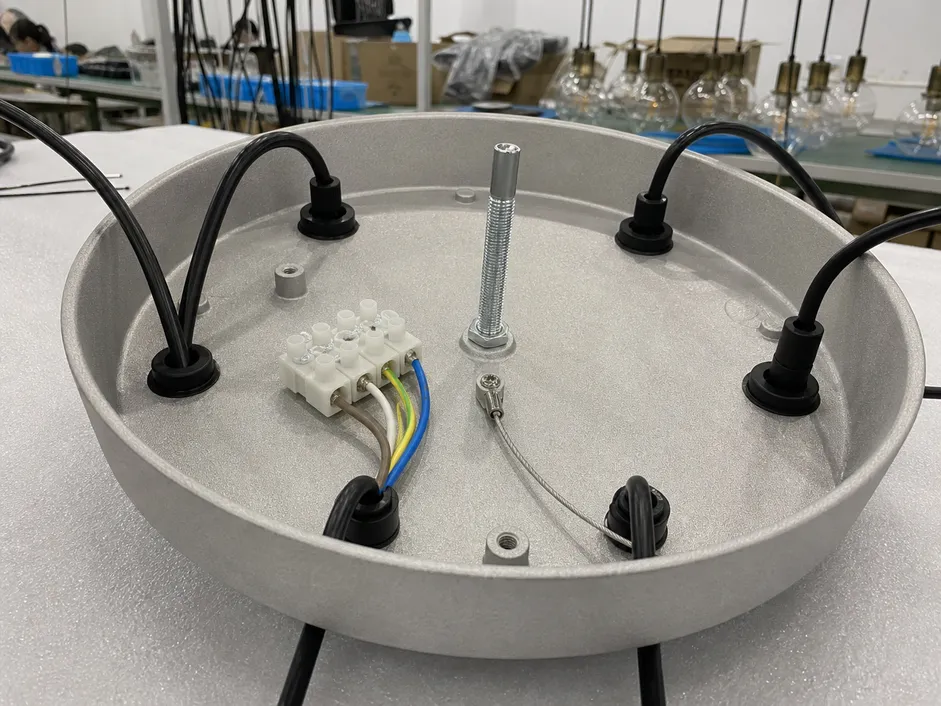 Die-cast aluminum canopy plate with terminal block wiring junction and strain relief grommets for cluster pendant fixture