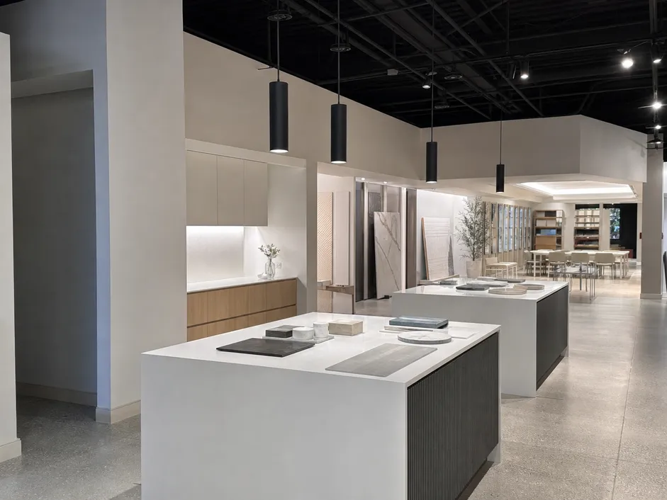 Cylinder pendant lighting over retail display tables in a commercial showroom interior