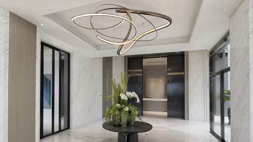 Custom entryway pendant lighting with PVD finish installed in a luxury residential tower foyer