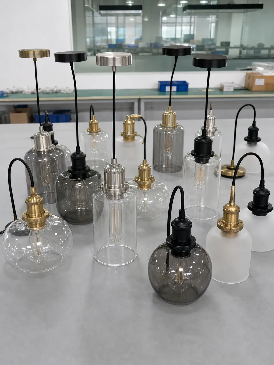 Collection of glass pendant lighting fixtures showing clear, frosted, and smoked glass options with various metal finishes