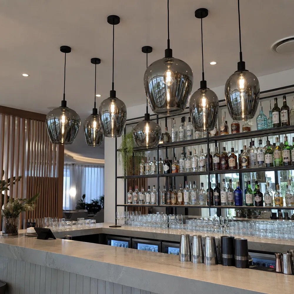 Smoked glass pendant lights clustered over a bar counter