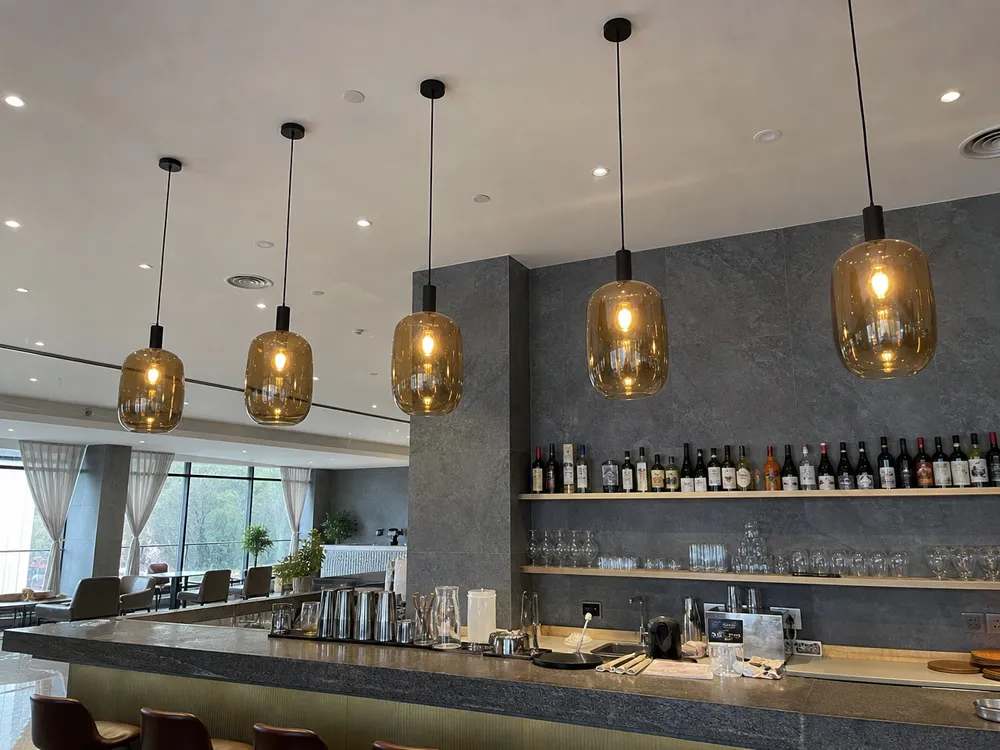 Smoked amber-tinted glass pendant in bar setting showing warm atmospheric light