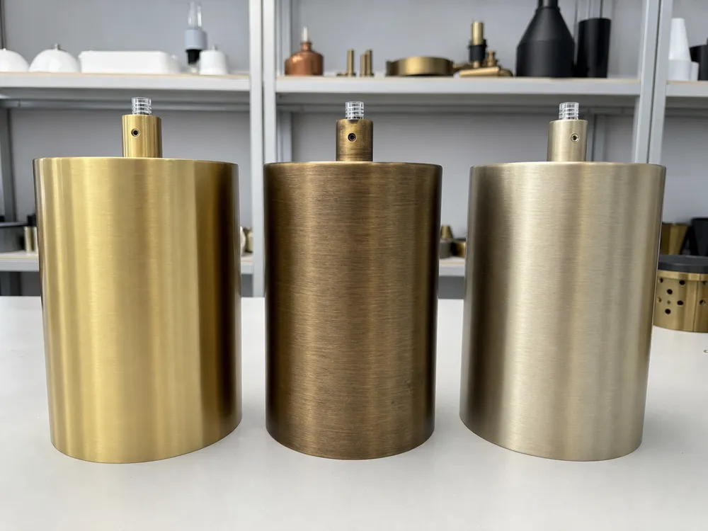 Custom PVD gold tone samples showing brushed gold, antique brass, and champagne gold finish variations on pendant lighting housings