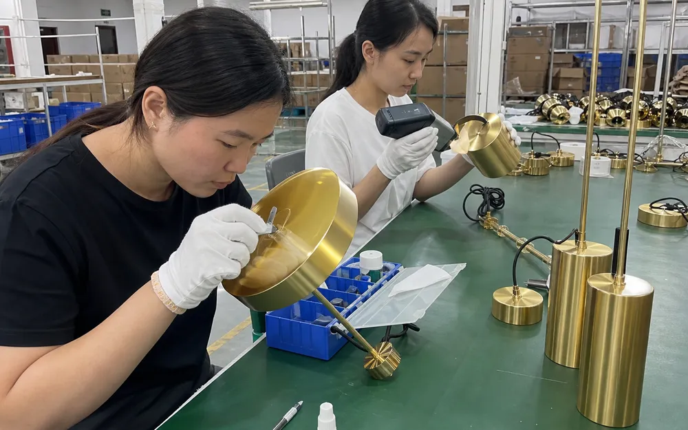 Quality control inspection of gold PVD finish on pendant lighting fixtures showing cross-cut adhesion testing and color measurement