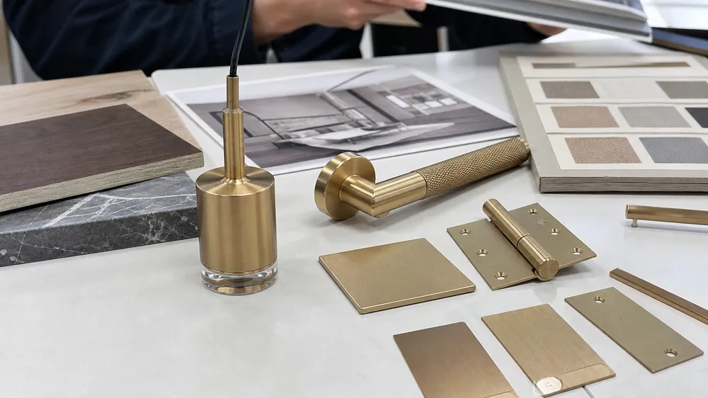 Custom champagne gold pendant finish sample alongside architectural hardware for specification matching