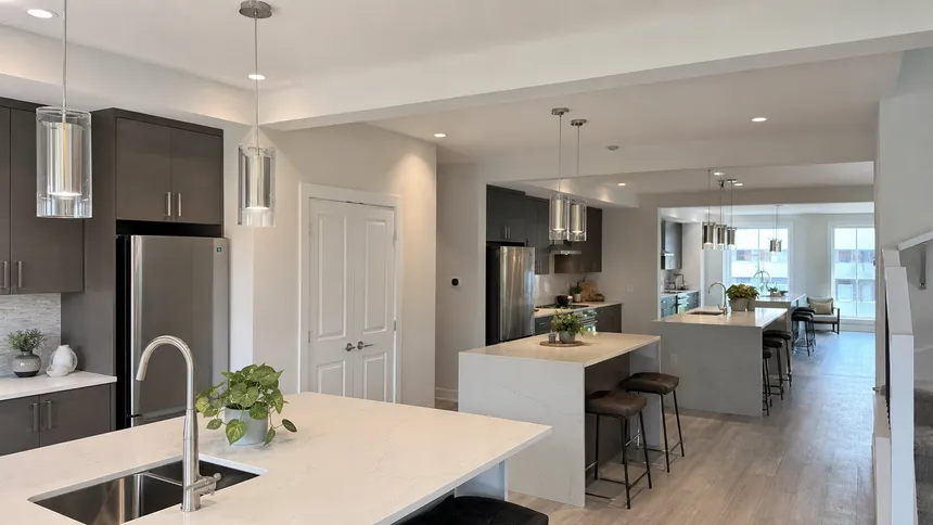 Modern cylinder and glass pendant lighting installed across multiple residential kitchen islands