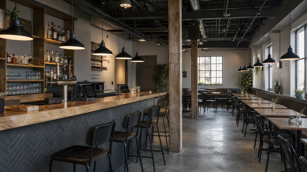 Industrial pendant lighting installed in a casual dining restaurant fit-out showing multiple fixtures over bar and dining areas