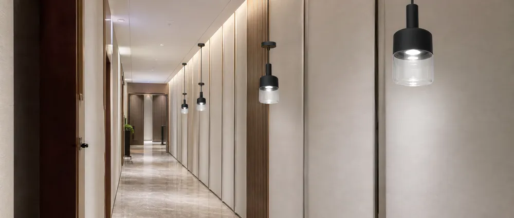 Modern pendant lighting installed in a hospitality corridor showing batch-consistent finish across multiple fixtures