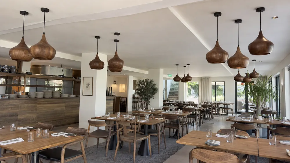Wood pendant lighting installed across boutique hotel dining area showing batch consistency