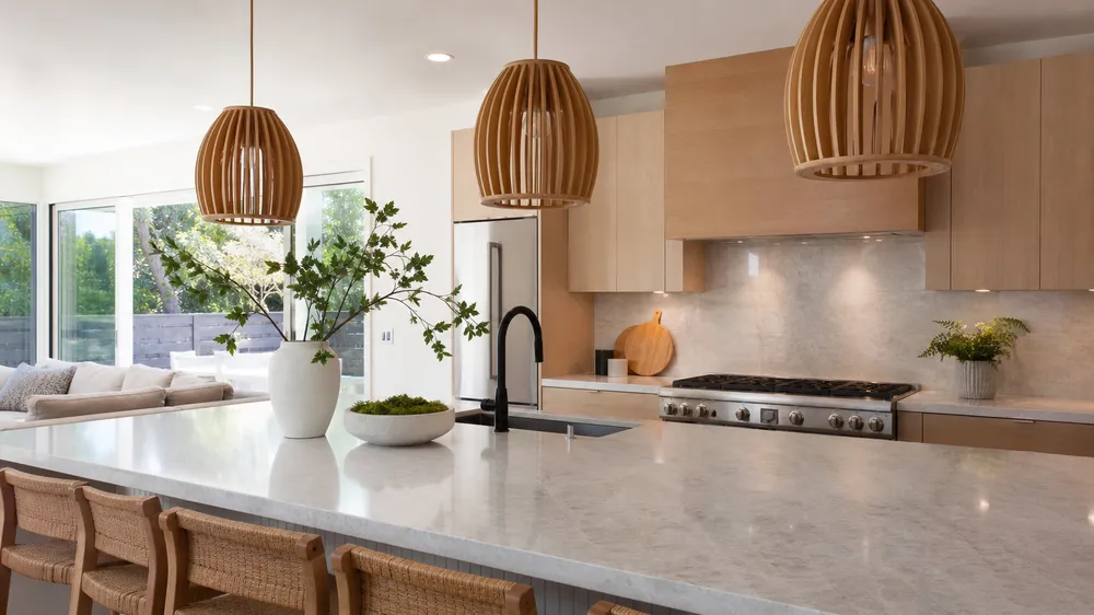 Wood pendant lighting over kitchen island in residential development showing biophilic design