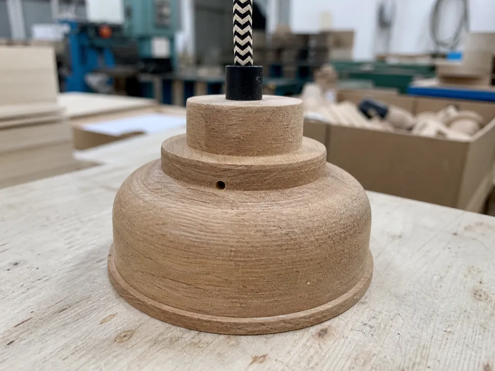 Close-up of solid wood pendant component showing natural grain character and moisture-stable construction