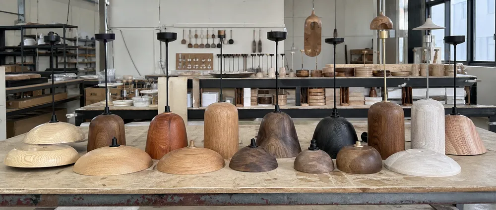 Range of wood pendant lighting showing different wood species, stain colors, and metal finish combinations available for OEM customization