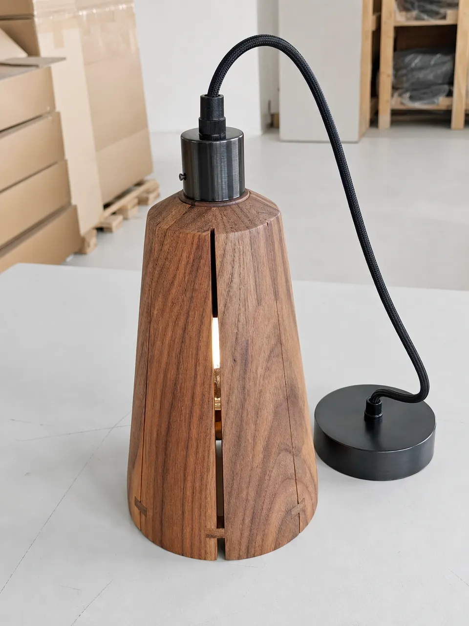 Solid wood pendant light with metal hardware, showing natural grain character and precision joinery