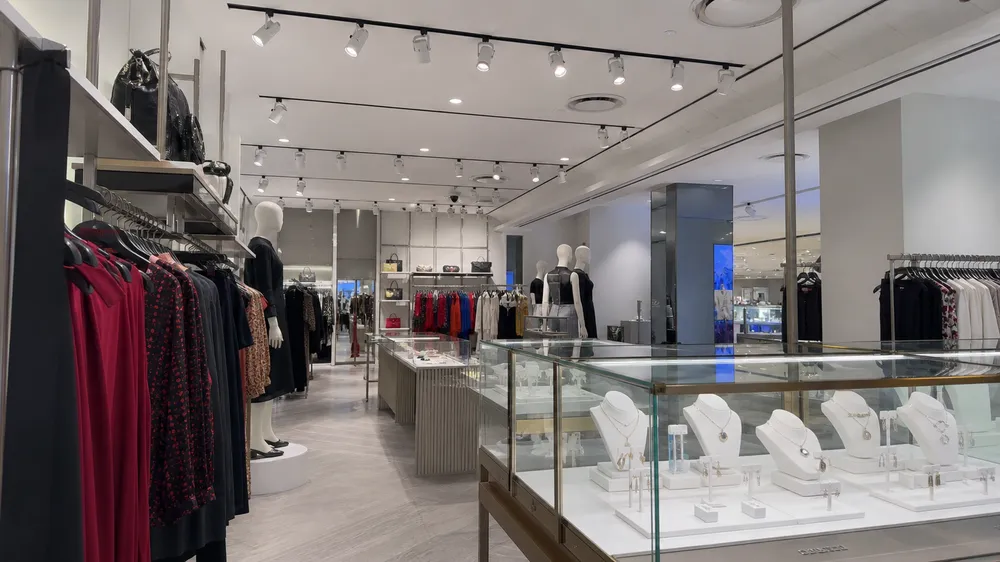 Retail store interior with adjustable spotlights illuminating fashion displays and jewelry counters