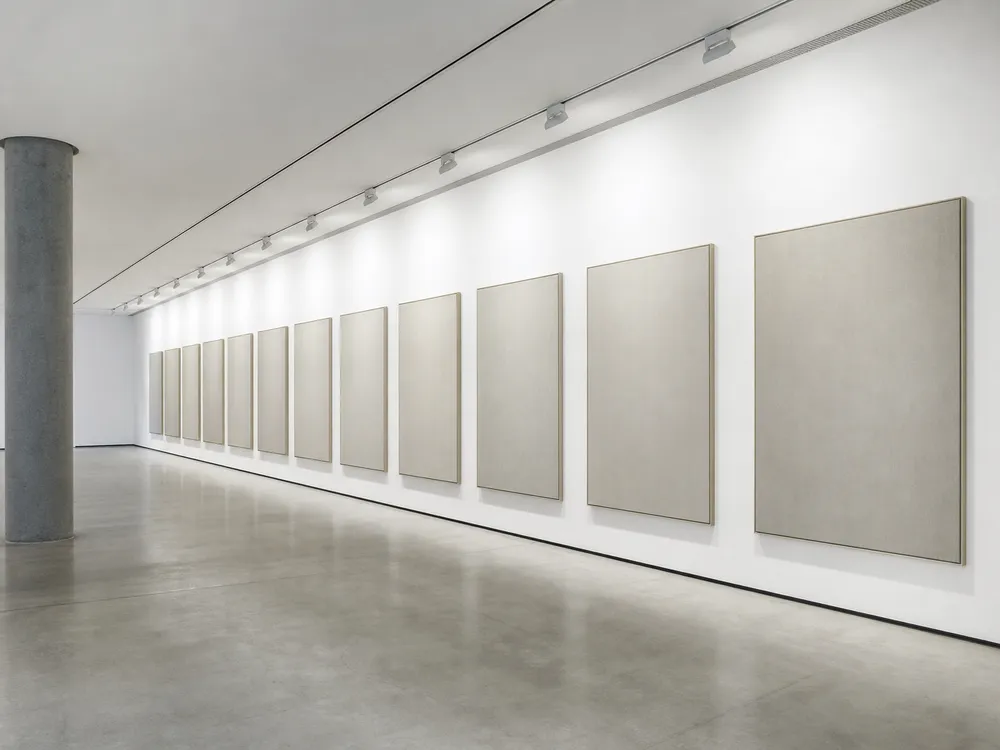 Wall washer lighting providing uniform illumination across gallery exhibition wall