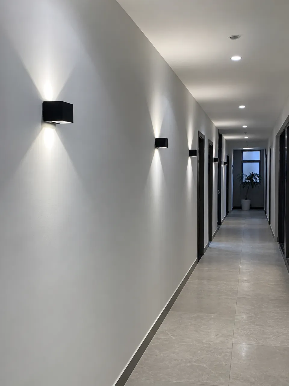 Hallway wall lighting fixtures installed in a modern corridor showing compact mounting profile and directional light distribution