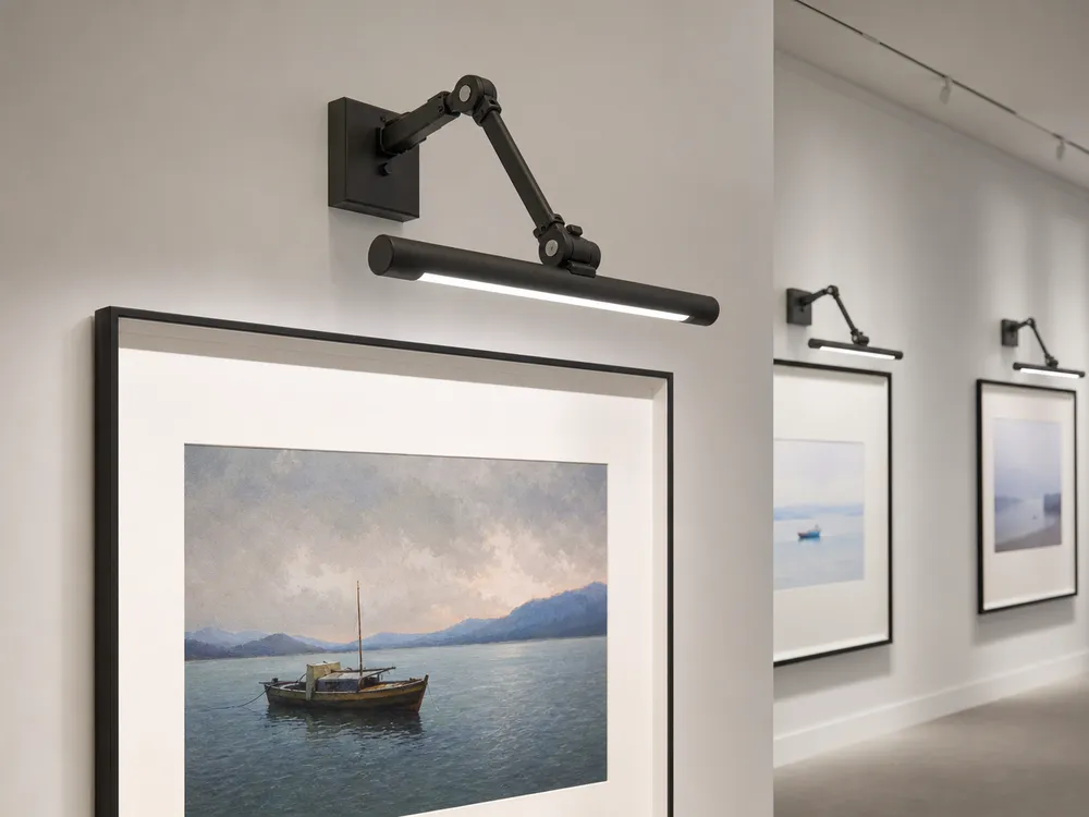 Adjustable-arm picture light illuminating framed artwork in a gallery setting