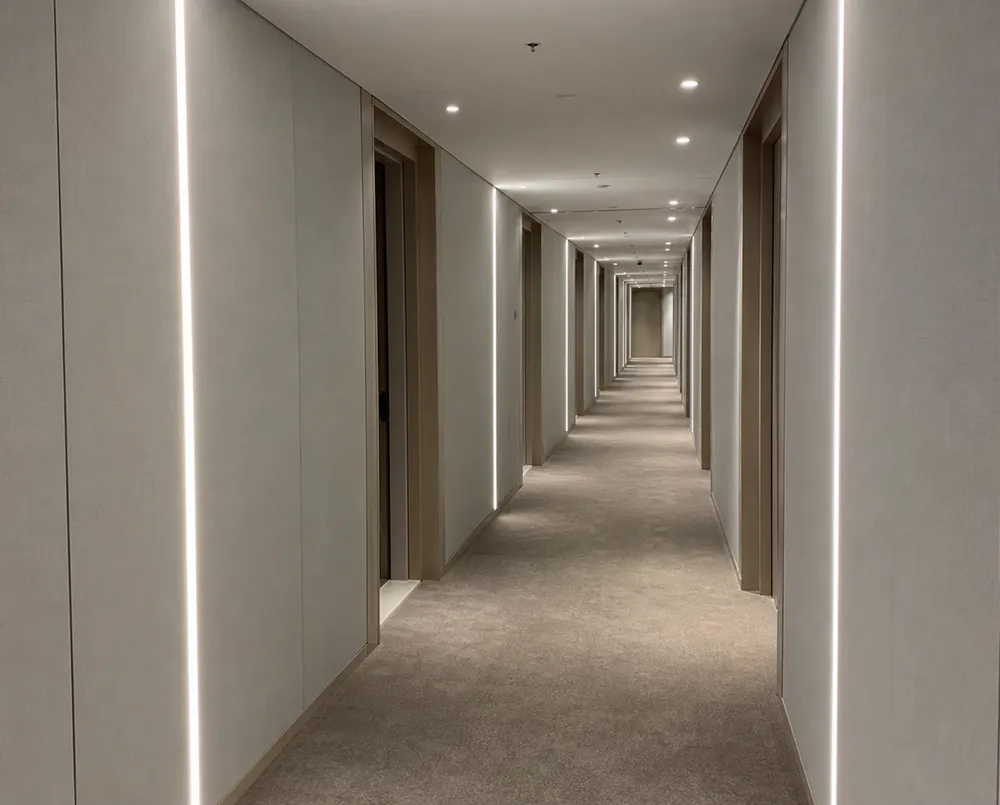 Linear wall lighting installed in a hotel corridor showing clean architectural lines and uniform light distribution