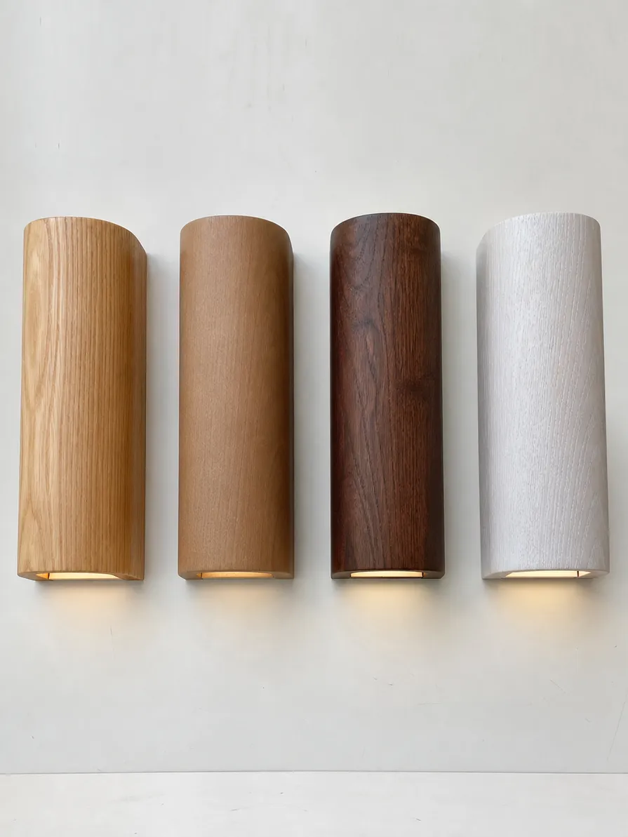 Comparison of natural oil, matte lacquer, dark stain, and whitewash finishes on wooden wall lighting samples